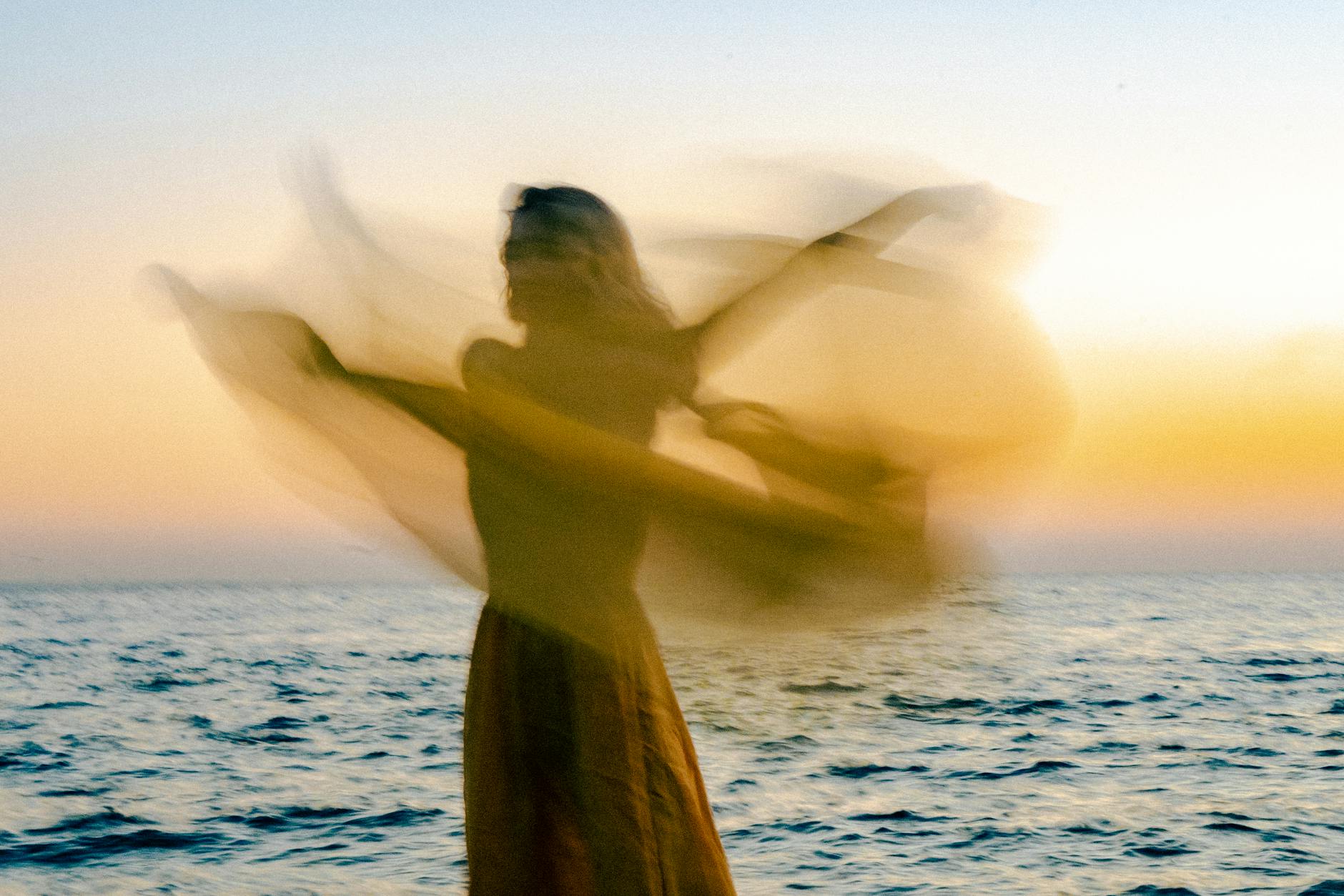 a woman dancing by a sea